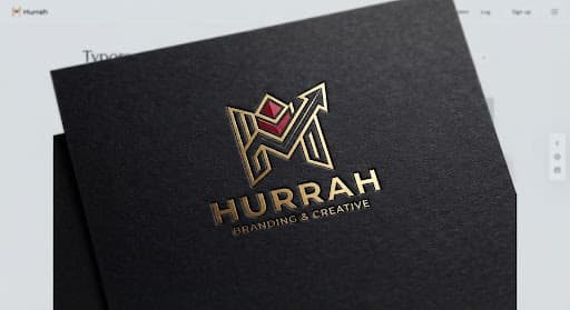Gold foil Hurrah logo on a black card